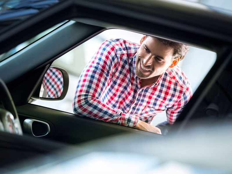 man leaning in window of automobile