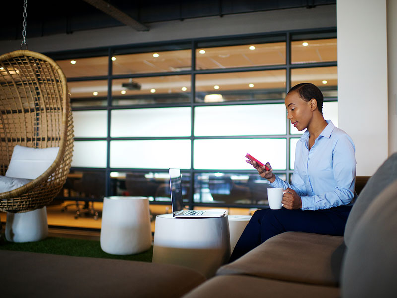 project manager sitting on sofa using phone