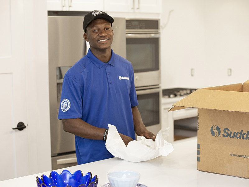 professional mover and packer wrapping up kitchen items