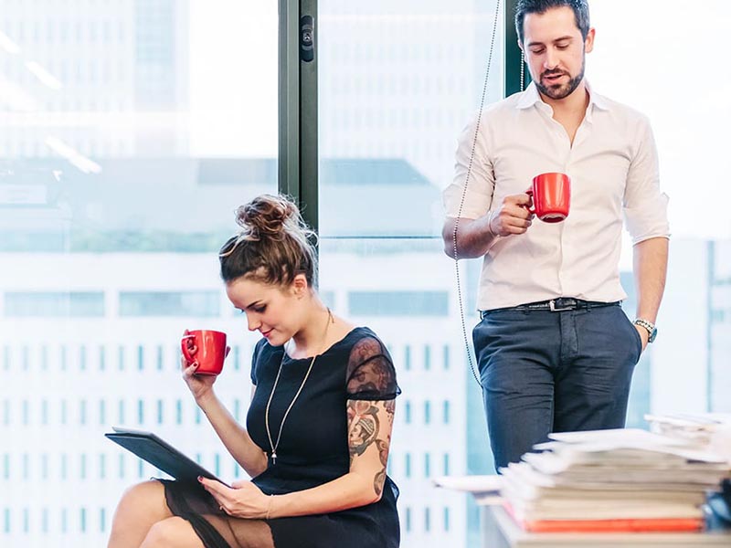 employees discussing international corporate relocation in breakroom