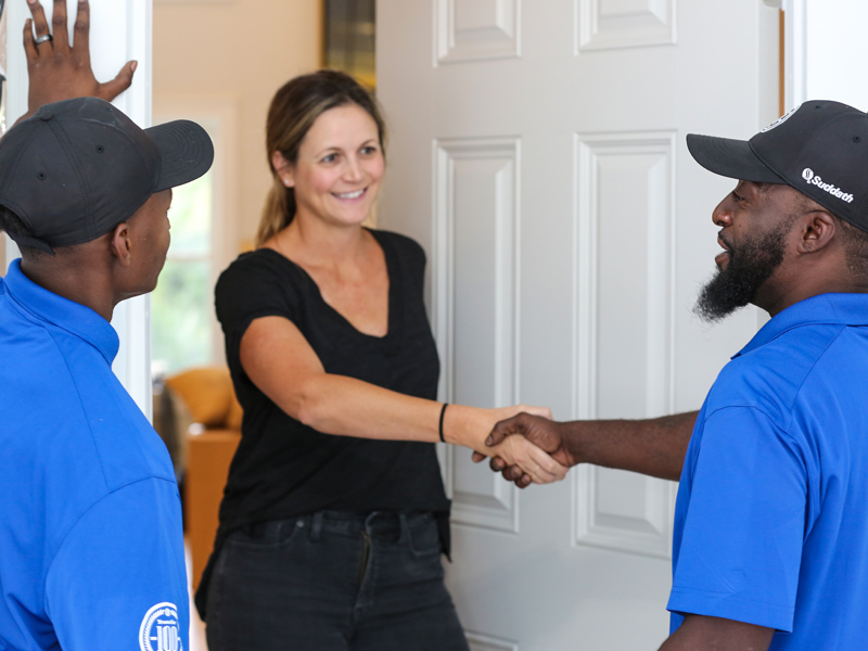 jacksonville local movers shaking hands with woman at front door