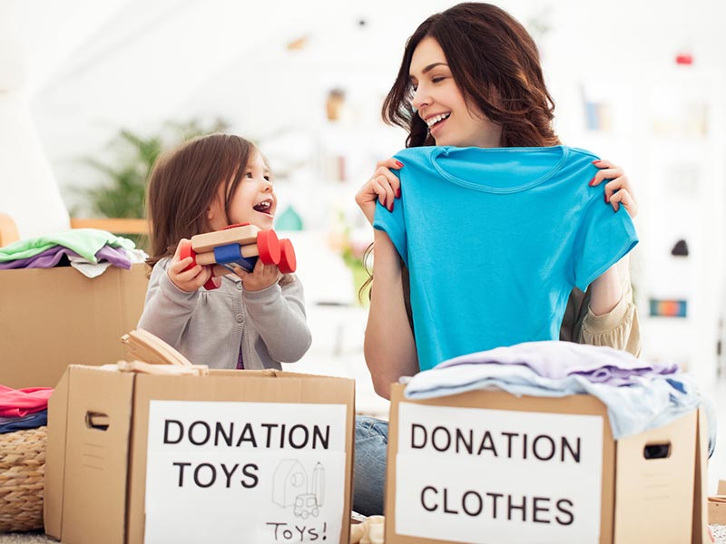 mother and daughter making toy and clothing donation boxes