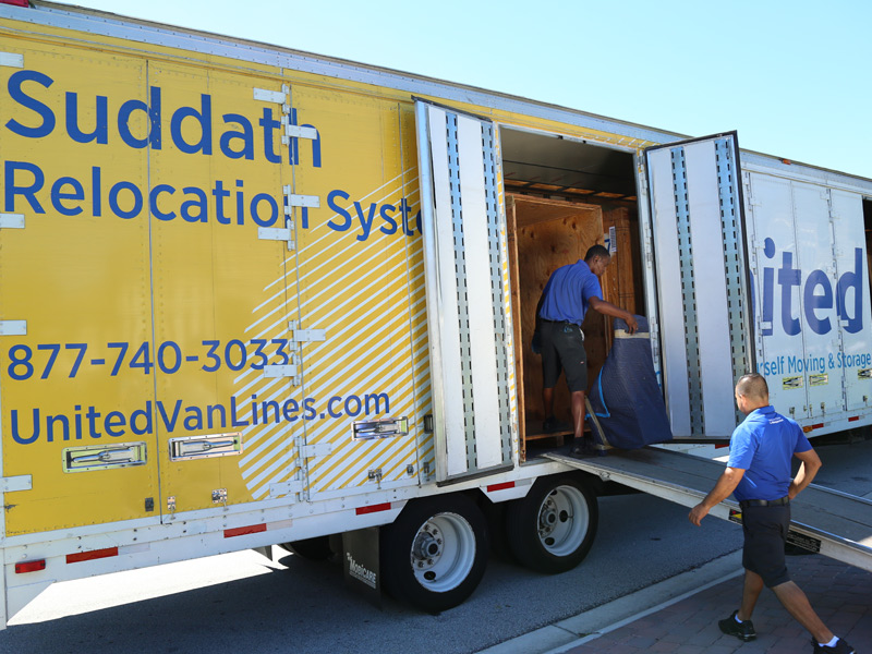 movers loading furniture on to moving truck
