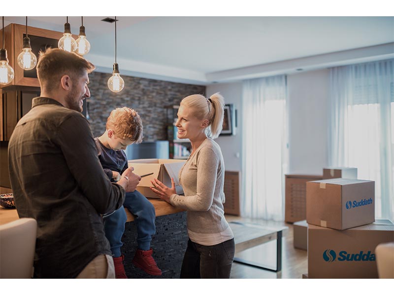 happy family in kitchen of new home with moving boxes