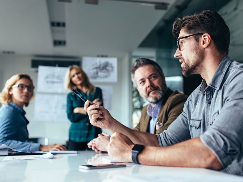 men and women having a conversation at a conference table