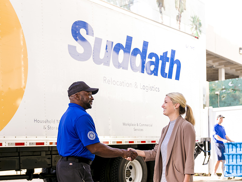 mover shaking womans hand in front of moving truck