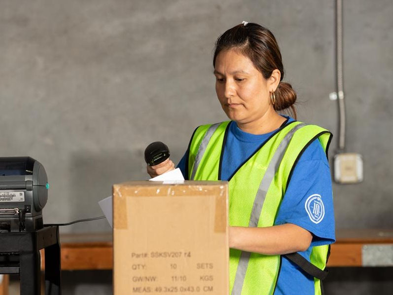 warehouse employees talking to man on forklift