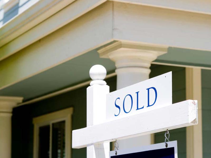white sold sign in front of home