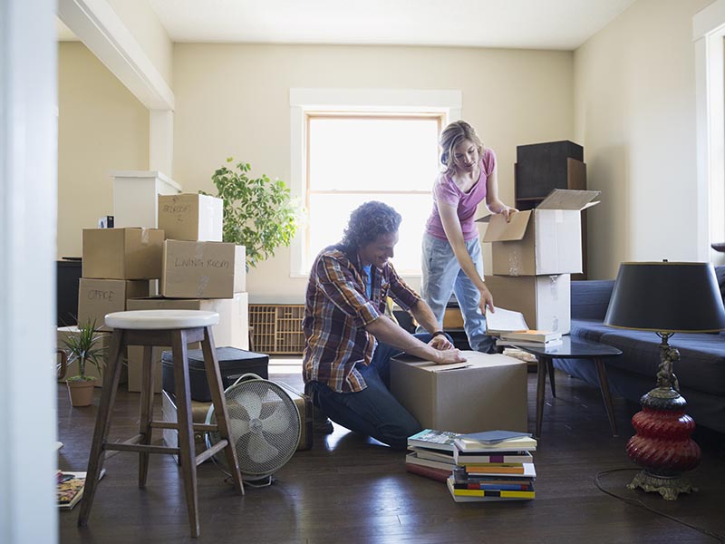 couple unpacking boxes in new home